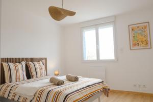 a white bedroom with a bed with a striped blanket at Les Embruns, 4 personnes in Criel-sur-Mer