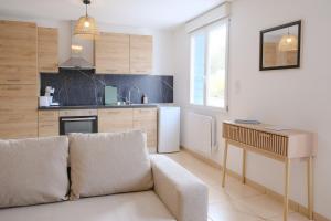 a living room with a couch and a kitchen at Les Embruns, 4 personnes in Criel-sur-Mer