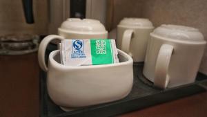 una taza blanca con un tubo de pasta de dientes y una botella de leche en Oriental Lander Hotel en Hong Kong