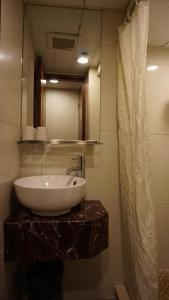 bagno con lavandino e specchio di Oriental Lander Hotel a Hong Kong