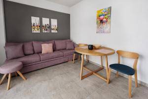 a living room with a purple couch and a table at FAOS Properties in Kavála