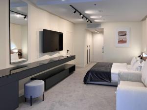 a bedroom with a bed and a flat screen tv at Rixos-Prykarpattya Resort in Truskavets