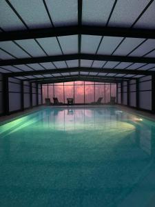 a large indoor swimming pool with a large pool at Chateau du boulay morin in Le Boulay-Morin