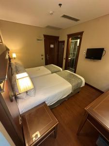 una camera d'albergo con un grande letto e una televisione di Hotel Perula & SPA a Istanbul