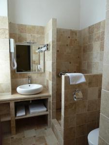 een badkamer met een wastafel en een spiegel bij Le Castelet des Alpilles in Saint-Rémy-de-Provence