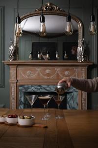 a person pouring a drink into two glasses on a table at Bleaton Hallet House Riverside Escape in Kingseat