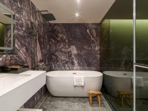 a bathroom with a large tub and a sink at The Zen in Jiufen
