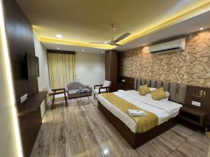a hotel room with a bed and a television at Hotel SHREE PALACE in Ratlām