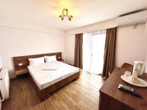 a hotel room with a bed and a window at Senin Vama Veche in Vama Veche