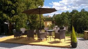 a table and chairs and an umbrella on a rug at Bibina in Levoča