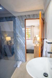 a bathroom with a tub and a bed and a sink at Apple Blossom Hotel Portfolio in Roodepoort