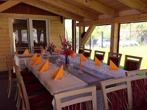 a long dining table with orange napkins and chairs at Bibina in Levoča