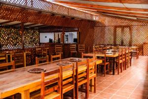 a dining room with wooden tables and chairs at Kê Vitamina - Solar dos Ananases in Santo Amaro
