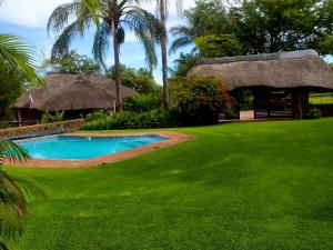 a resort with a pool and a grass yard at Lapa Phanzi Game Lodge in Modimolle