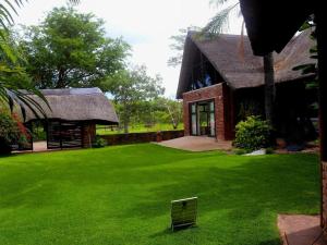 a house with a grass yard next to a building at Lapa Phanzi Game Lodge in Modimolle