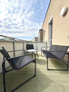 two chairs and a table on a balcony at Seelavie in Podersdorf am See