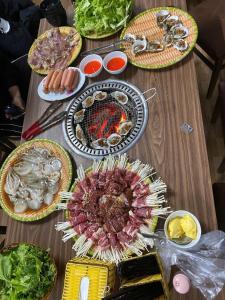 a wooden table with plates of food on it at Khế Homestay Phố Cổ Ninh Bình in Ninh Binh
