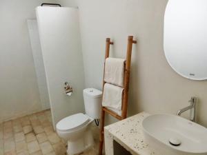 a bathroom with a white toilet and a sink at Palmhouse Boutique Hotel in Kuta Lombok