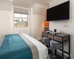 a hotel room with a bed and a flat screen tv at Linen Bank Residence - Aparthotel in Linlithgow