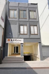 a gray building with a sign on the front of it at 亀井町Stay401 in Takamatsu