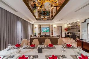 a dining room with a long table with red flowers at Ninh Binh Legend Hotel in Ninh Binh