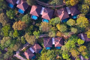 an overhead view of cars parked in a forest at The Leela Coorg Forest Sanctuary in Madikeri