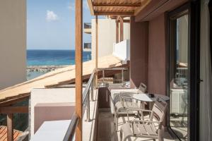a balcony with chairs and a table and a view of the ocean at Infinity City Boutique Hotel in Heraklio