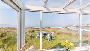 a dining room with a view of the ocean at C35 Le Grace, Riviere Towans in Hayle