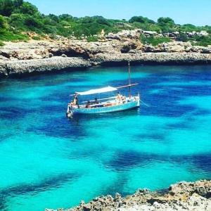 a boat floating in a body of water at Finca CanFirella Portocolom in Felanitx