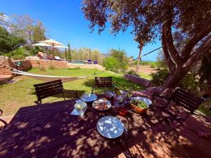 a picnic table with food on it under a tree at Finca CanFirella Portocolom in Felanitx