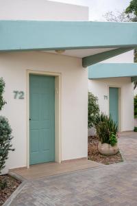a building with a green door on it at כפר נופש קלי"ה ים המלח in Kalia