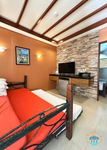 a bedroom with a bed and a desk with a television at Palmas Del Mar Resort Bacolod in Bacolod +67 photos