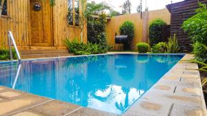 a swimming pool in a backyard with a wooden fence at THE WOODEN HOUSE in Moshi