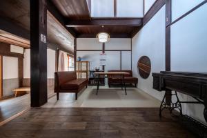a living room with a piano and a table at Oyajino Umi in Naoshima