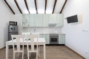 a kitchen with white cabinets and a table and chairs at Canary House in Ingenio +26 photos