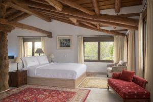 a bedroom with a bed and a couch and windows at Casa Malinalco Hotel Boutique & Restaurante in Sotosalbos
