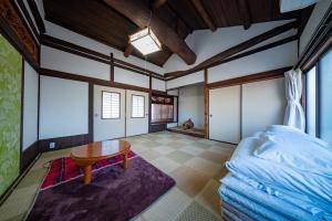 a room with a bed and a table in it at Oyajino Umi in Naoshima