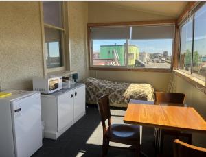 a room with a room with a table and a kitchen at Railway Hotel Greymouth in Greymouth