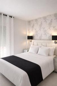 a white bedroom with a large white bed with white pillows at Abril Nerja in Nerja +29 photos