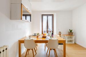 a kitchen and dining room with a wooden table and chairs at The Nest Between Lake Como e Bellagio in Castelmarte
