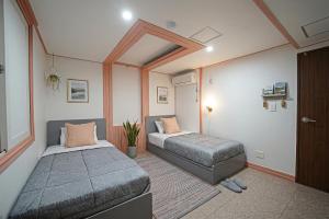 a bedroom with two beds in a room at Midpoint Guesthouse in Busan