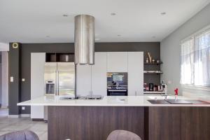 a kitchen with a large white island in a room at Superbe Villa, 4 chambres, parking, garage et piscine in Genas