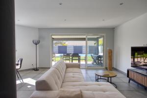 a living room with a couch and a tv at Superbe Villa, 4 chambres, parking, garage et piscine in Genas