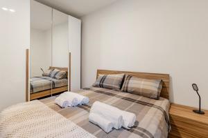 a bedroom with two beds and a mirror at The Nest Between Lake Como e Bellagio in Castelmarte