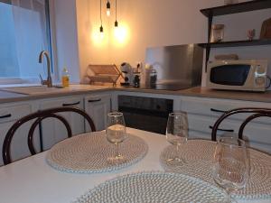 two empty wine glasses sitting on a table in a kitchen at Cozy countryside apartment in Moriville
