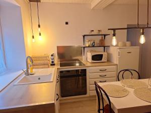 a small kitchen with a sink and a microwave at Cozy countryside apartment in Moriville +8 photos