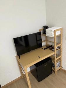 a wooden desk with a television on a wall at 亀井町Stay501 in Takamatsu