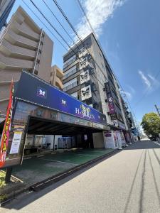 a building with a blue sign on the side of a street at H-Seven Nishikawaguchi (Adult Only) in Kawaguchi