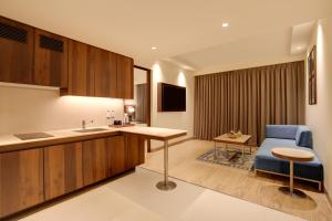 a kitchen with a table and a blue chair in a room at Keys Prima by Lemon Tree Hotels, Whitefield, Bengaluru in Bangalore