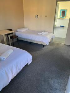 a room with two beds and a table and a desk at Walla Walla Hotel Motel in Walla-Walla
